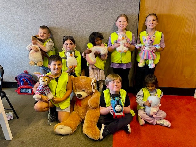Children posing together with their soft toys